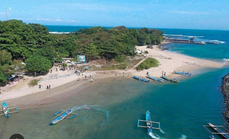 Pemandangan pantai pasir putih dan perahu tradisional di Pantai Santolo, Garut, dengan suasana tenang dan laut biru.